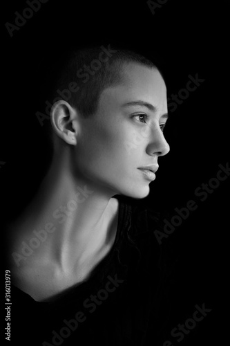 black and white portrait of fashion beautiful model, brunette girl with very short hair in studio, close up, young bold woman head shot 