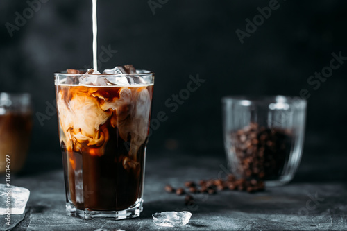 Canvastavla Milk Being Poured Into Iced Coffee on a dark table