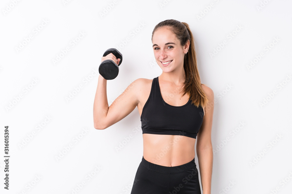 Young caucasian sporty woman holding a dumbbell Young caucasian sporty woman holding a dumbbell