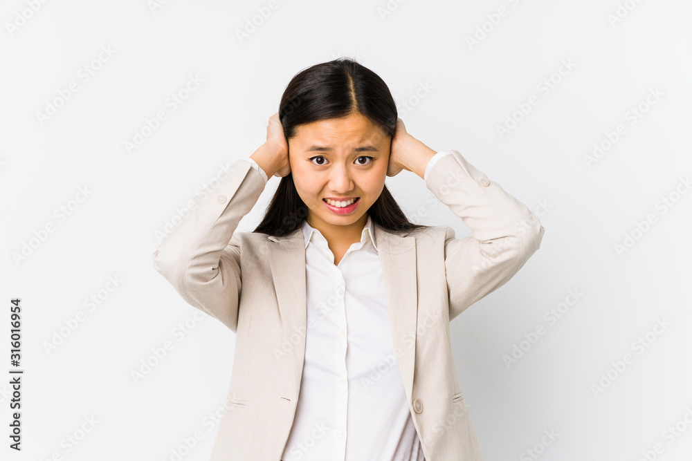 Young chinese business woman isolated covering ears with hands trying not to hear too loud sound. Young chinese business woman isolated covering ears with hands trying not to hear too loud sound.