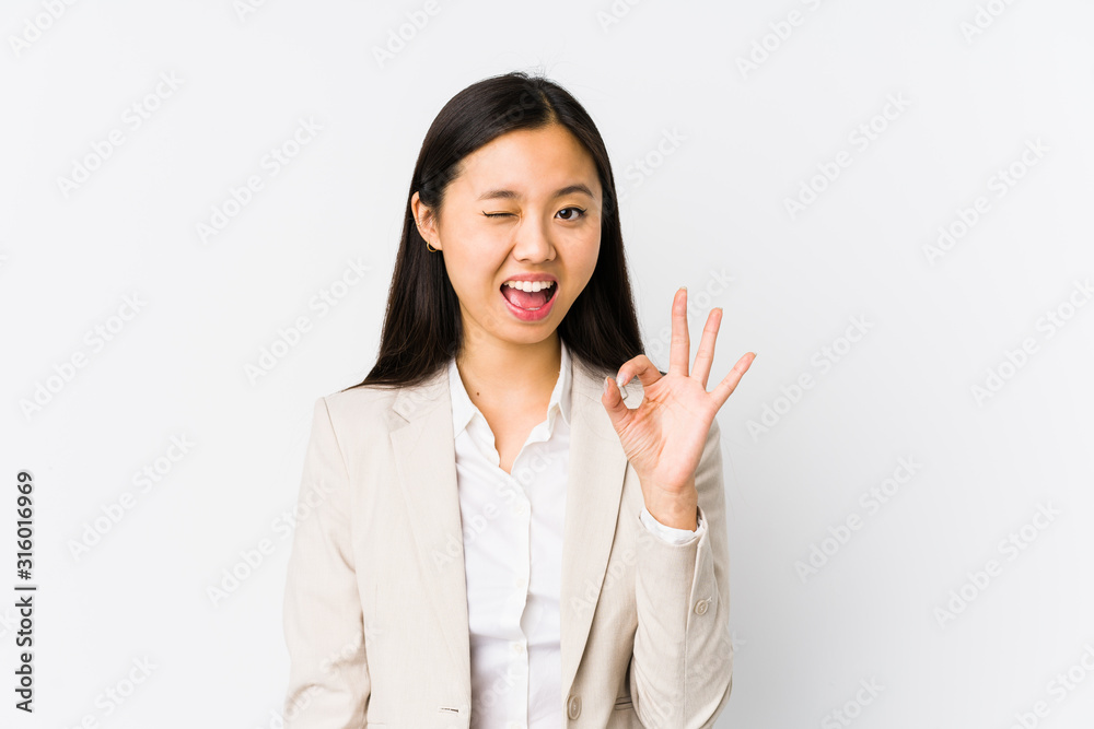 Young chinese business woman isolated winks an eye and holds an okay gesture with hand. Young chinese business woman isolated winks an eye and holds an okay gesture with hand.