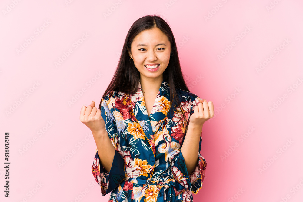 Young chinese woman wearing a kimono pajama isolated cheering carefree and excited. Victory concept. Young chinese woman wearing a kimono pajama isolated cheering carefree and excited. Victory concept.