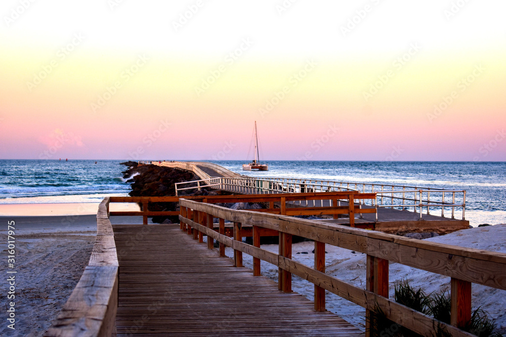 Obraz premium Idyllic Sunset Sailing at the Ponce Inlet Jetty Along the East Coast ofFlorida