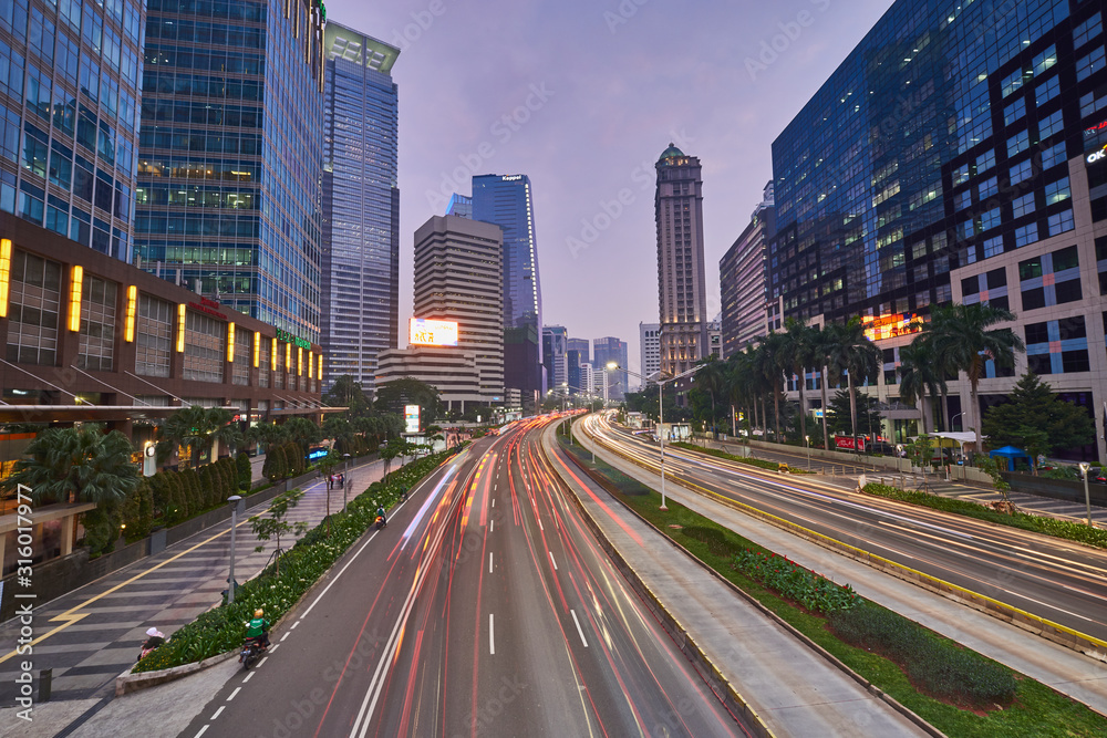 Light trails on the busy traffic surrounded by Jakarta business office buildings 