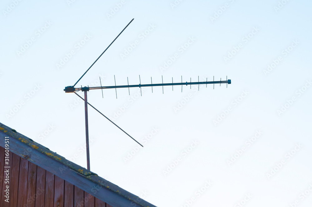 Old directional antenna for tv and internet installed on the roof of the  house or building.