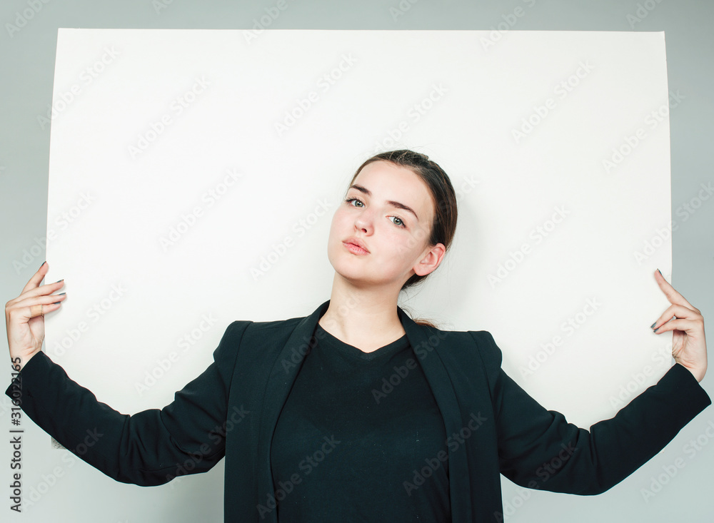 young pretty brunette girl with placard on white background wearing business costume student, lifestyle people concept young pretty brunette girl with placard on white background wearing business costume student, lifestyle people concept