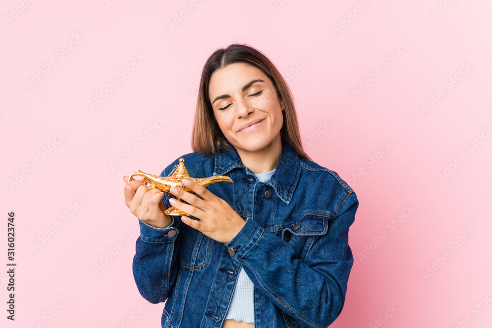 Young caucasian woman holding a magic lamp isolated Young caucasian woman holding a magic lamp isolated