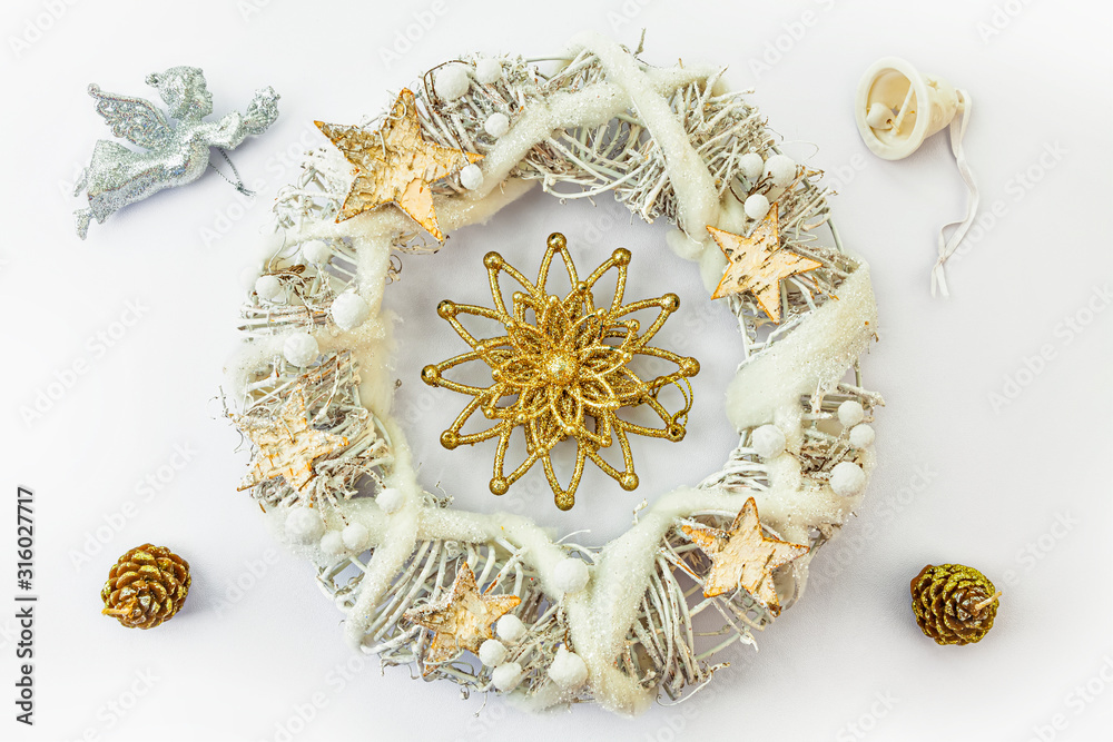 Christmas wreath made from dried twigs, decorated with stars, angel, cones and bell.