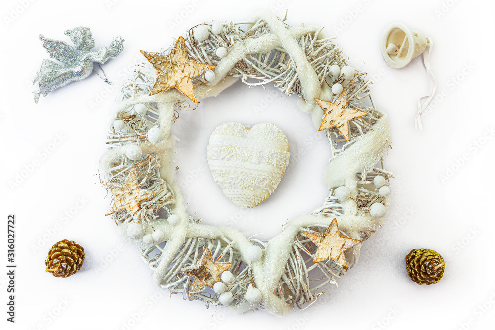 Christmas wreath made from dried twigs, decorated with heart, stars, angel, cones and bell.