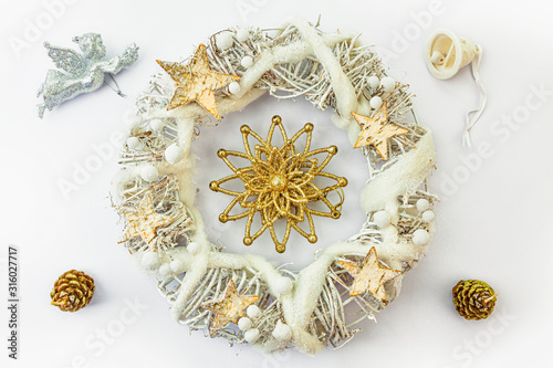 Obraz na płótnie Christmas wreath made from dried twigs, decorated with stars, angel, cones and bell. w salonie