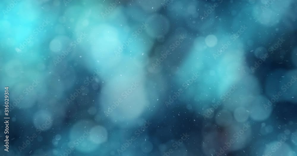 Abstract blurry turquoise blue bokeh with snow falling. Artistic snowflakes copy space background.