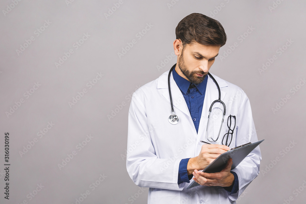 Serious doctor writing recipe on clipboard, isolated on grey background. Serious doctor writing recipe on clipboard, isolated on grey background.