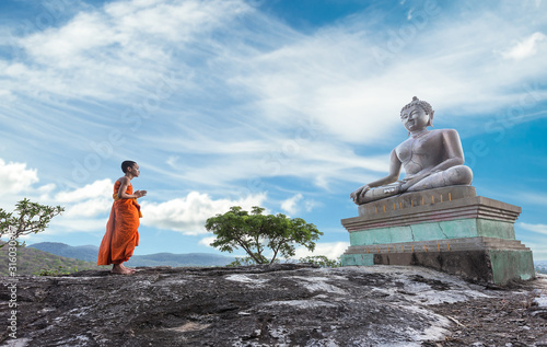 Photography Novice Monk praying to the Buddha in Phrabuddhachay Temple, Saraburi, Thailand