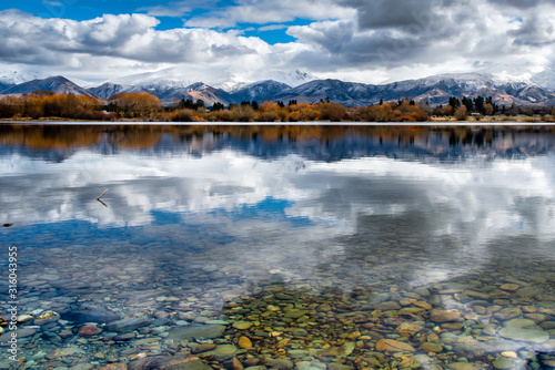 The crystal clear water and amazing reflections of Lake Opuha with the snow capped Southern Alps in the background