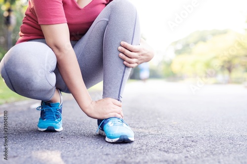 Fotografie Woman runners hurt their knees from a heavy stroke at the park.