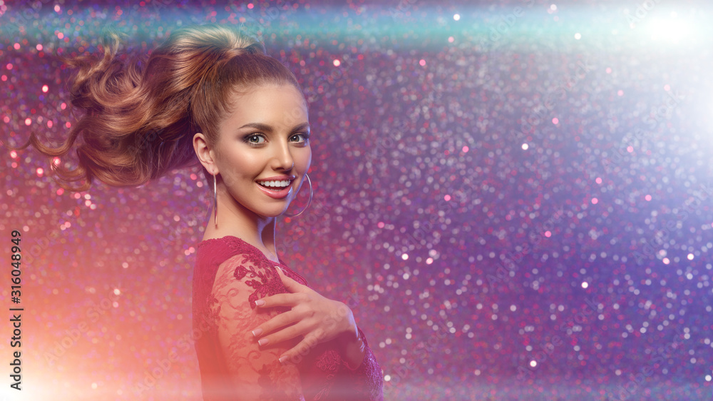 Red beautiful fashion woman, model with shiny healthy long volume hair in high tail. Waves curls updo volume hairstyle. Hair Salon.Girl with luxurious haircut on red background