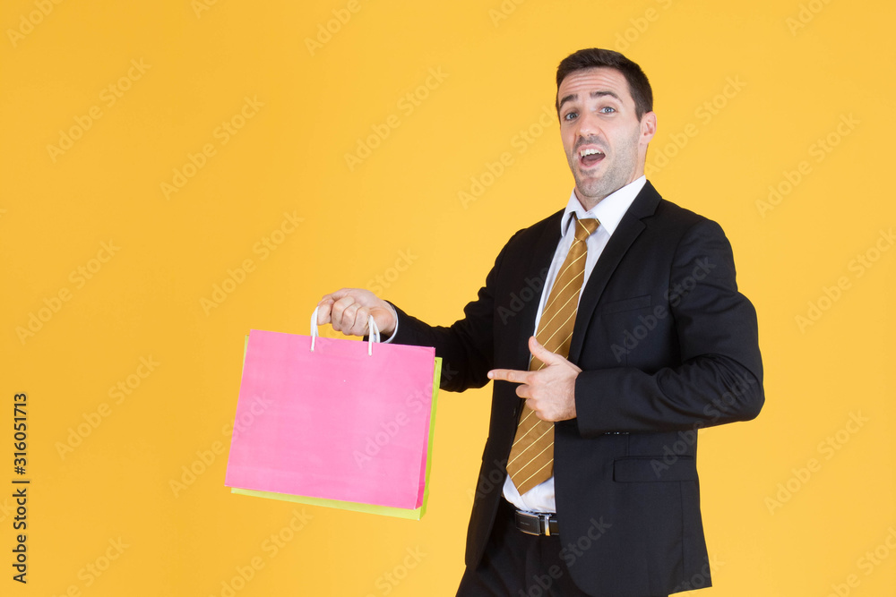 Portrait of businessman with shopping bags on yellow background. Portrait of businessman with shopping bags on yellow background.