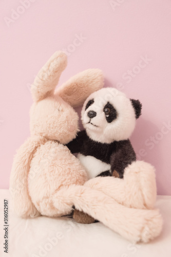 Fototapeta Naklejka Na Ścianę i Meble -  Plush panda and bunny hugging each other