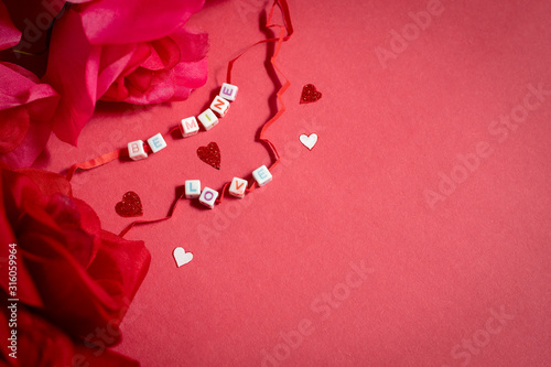 Valentine's Day Red Background with Letter Beads Spelling out Be Mine and Love with Red Roses and Confetti
