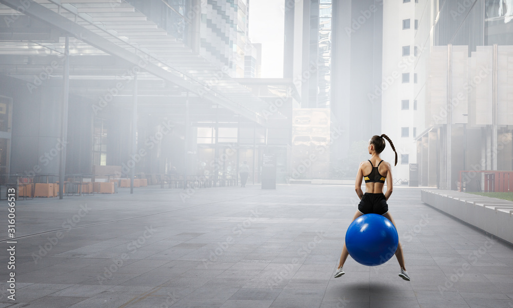 Sporty woman on fitness ball. Mixed media Sporty woman on fitness ball. Mixed media