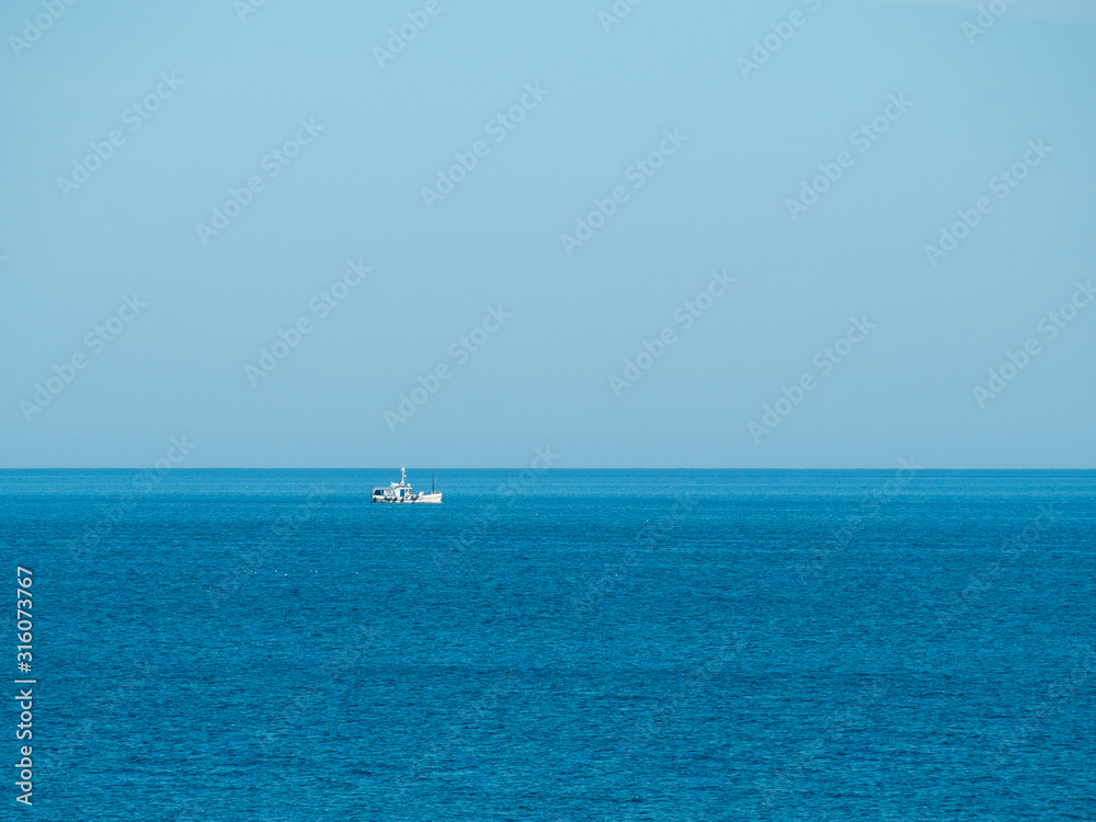 A fishing boat is engaged in fishing in the calm open sea. Baltic sea A fishing boat is engaged in fishing in the calm open sea. Baltic sea
