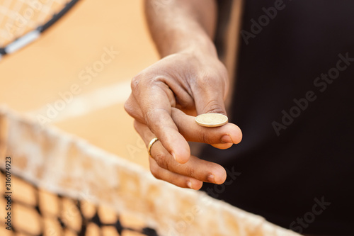 Fotografie Close up of referee hands flipping a coin before starting the game or match