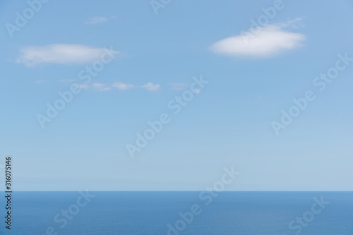 Aerial view of calm Tasman sea with few white clouds in day light © Emagnetic