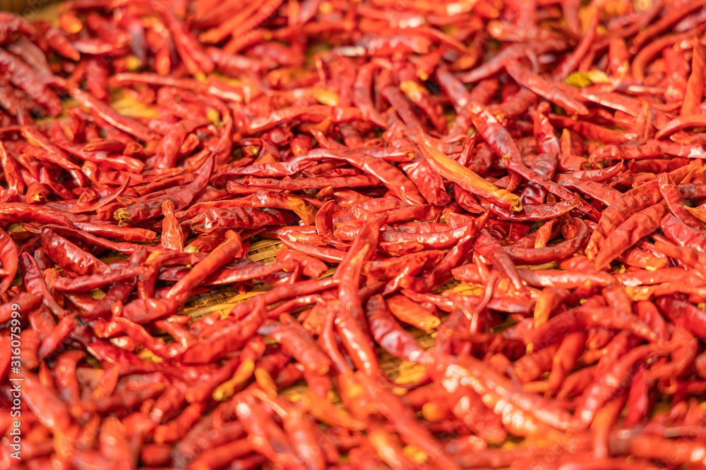 Fototapeta premium Red dried chili on bamboo basket background.Selective focus.