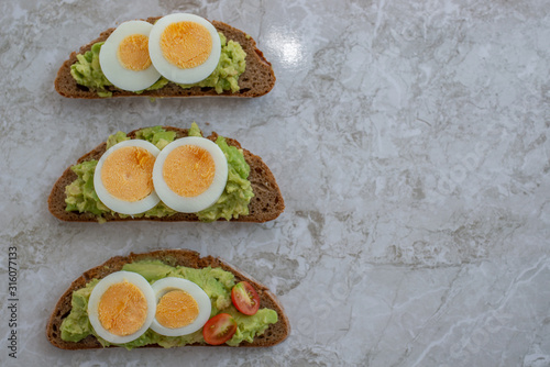 sliced avocado and egg on toasted bread for healthy breakfast or snack