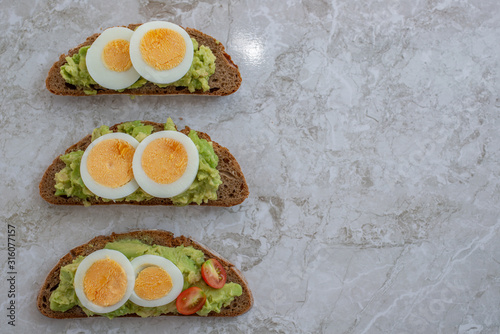 sliced avocado and egg on toasted bread for healthy breakfast or snack