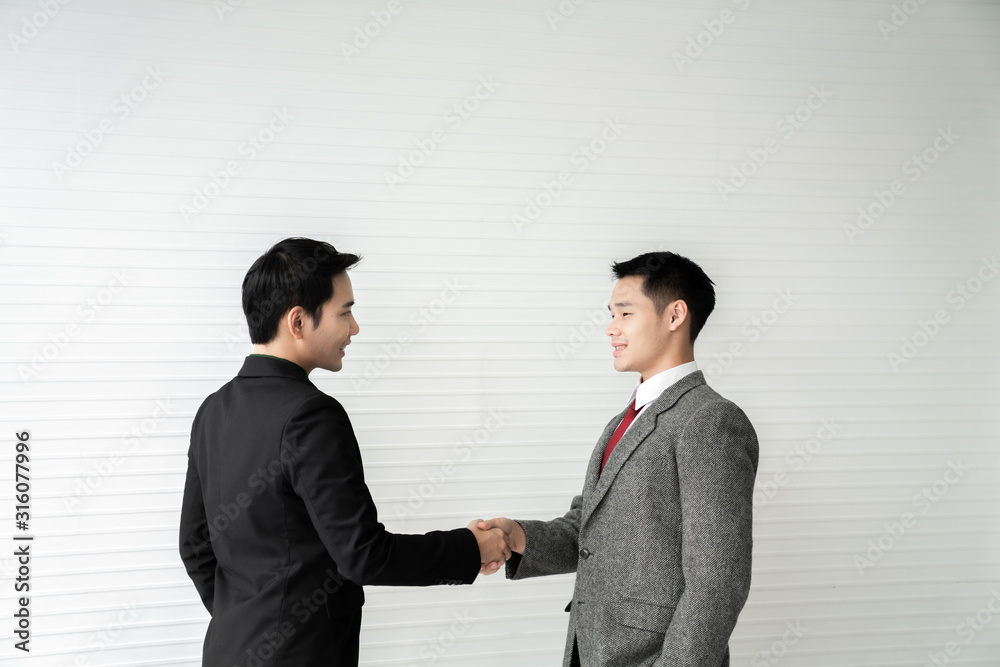 Business deal / two businessman handshake on white background / business concept /asian model Business deal / two businessman handshake on white background / business concept /asian model