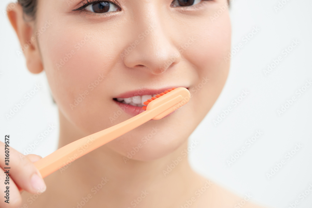 Happy young woman brushing teeth . Happy young woman brushing teeth .