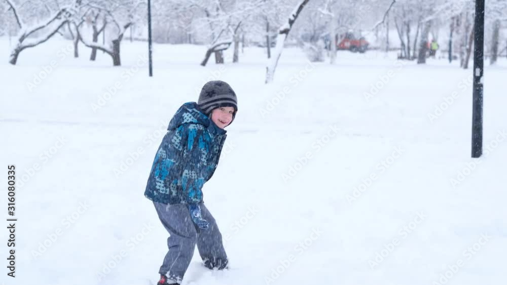 Happy child playing snowball in snowy winter day, christmas holidays Happy child playing snowball in snowy winter day, christmas holidays