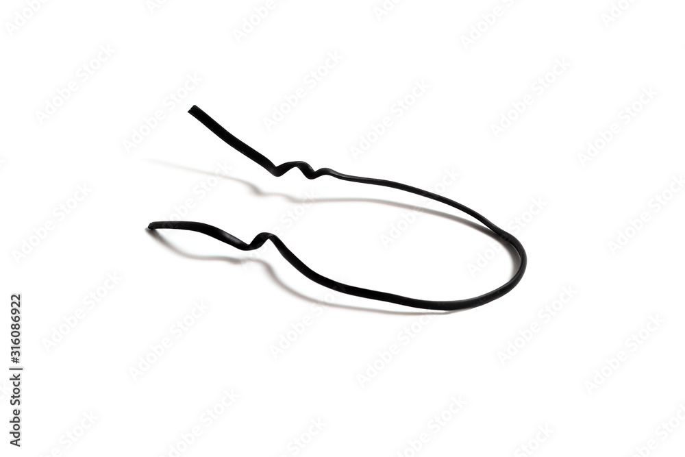 Black used piece of wire for pulling electric cables and other things on a  white background isolate. Black plastic coated wire tie. Cable flexible tie  tools for packing. Top view. Stock Photo