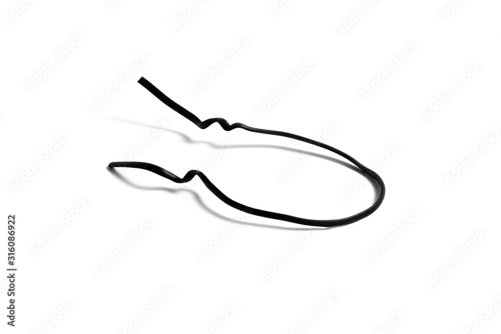 Black used piece of wire for pulling electric cables and other things on a white background isolate. Black plastic coated wire tie. Cable flexible tie tools for packing. Top view.