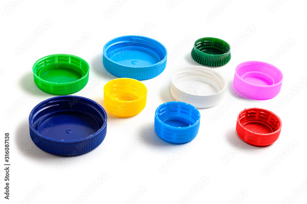 Colored plastic caps from bottles of water isolated on a white background. Close-up, top view. The pollution of Earth. Recycling used plastic - a solution to the problem of plastic contamination. Colored plastic caps from bottles of water isolated on a white background. Close-up, top view. The pollution of Earth. Recycling used plastic - a solution to the problem of plastic contamination.