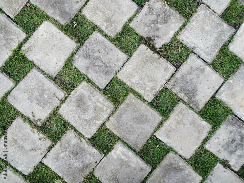Rectangle-shaped paving blocks and green grass as landscape surface material Rectangle-shaped paving blocks and green grass as landscape surface material