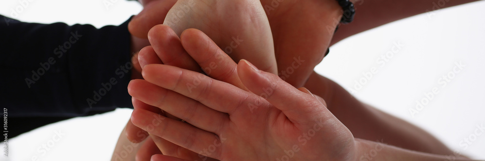 Group of people in suits crossed hands in pile for win closeup. White collar leadership high five cooperation initiative achievement corporate life style friendship deal heap stack concept Group of people in suits crossed hands in pile for win closeup. White collar leadership high five cooperation initiative achievement corporate life style friendship deal heap stack concept