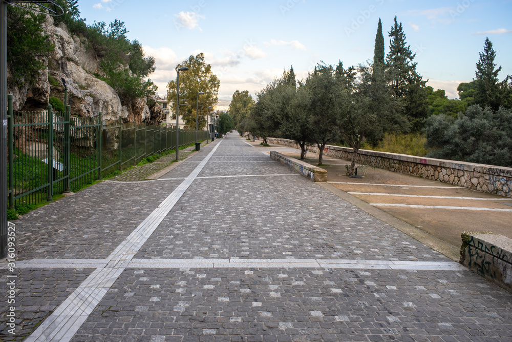 Athens, Greece, Dionysiou Areopagitou street, early morning with no people.  Pedestrian walkway under acropolis hill.
