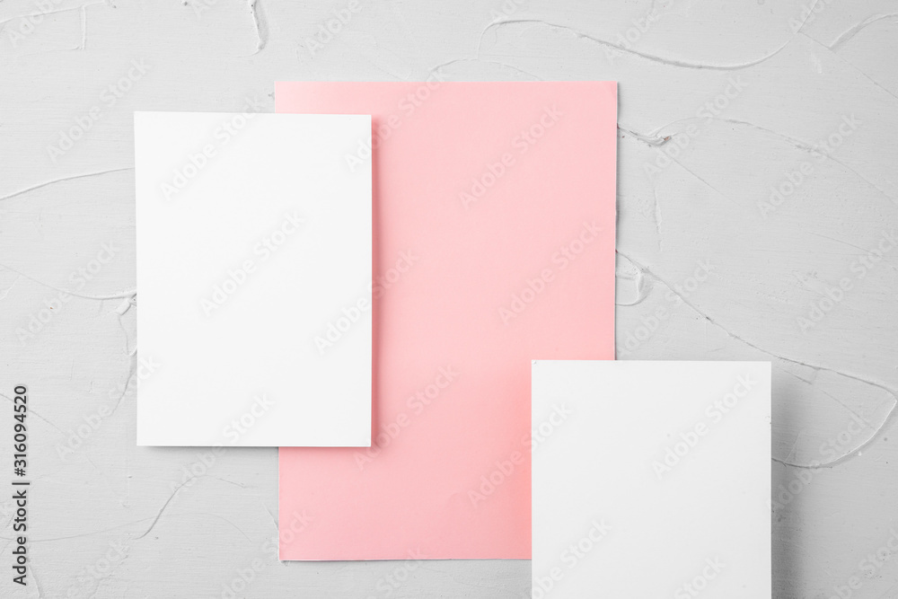Three pieces of blank paper on grey background, top view, copy space Three pieces of blank paper on grey background, top view, copy space