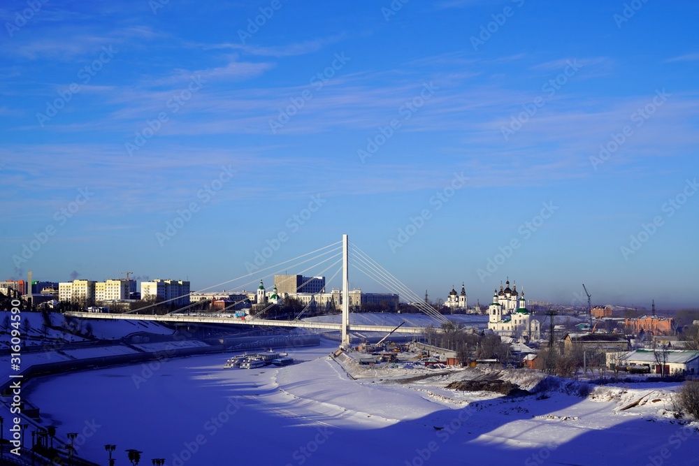 Panoramic view on bridge over icy river in winter sunny day