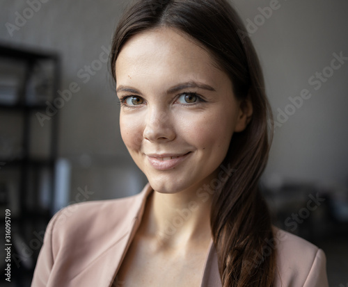 Close up of young attractive woman. Milennial businesswoman smiles. Relaxed beatiful female with attractive smile.