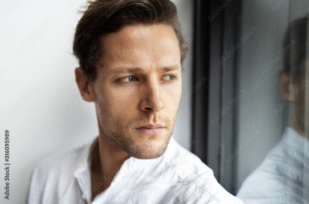 Portrait of young confident man looking at the window. Handsome milennial well-dressed good-looking attractive businessman. Portrait of young confident man looking at the window. Handsome milennial well-dressed good-looking attractive businessman.