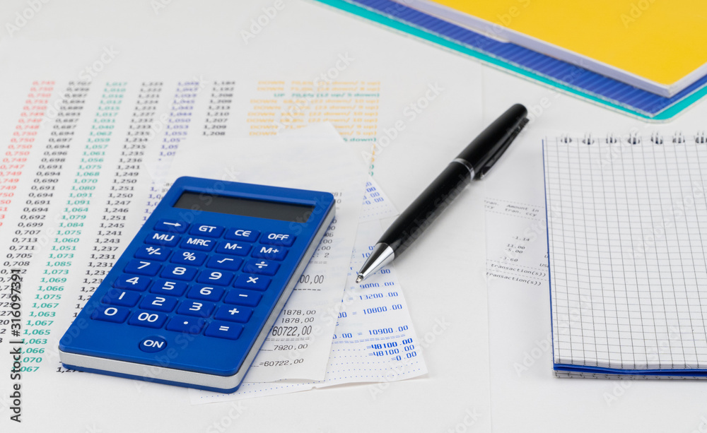 Calculator and notepad on top of supermarket receipt. Shopping and payment concept Calculator and notepad on top of supermarket receipt. Shopping and payment concept