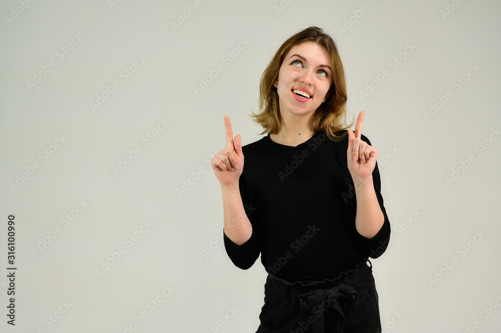 Studio portrait of a pretty blonde girl in a black T-shirt on a white background with bright emotions. A universal concept, the picture is suitable for any topic. Studio portrait of a pretty blonde girl in a black T-shirt on a white background with bright emotions. A universal concept, the picture is suitable for any topic.