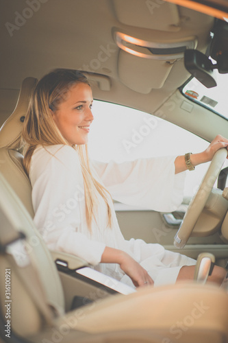 Pretty, young woman driving a car -Invitation to travel. Car rental or vacation.