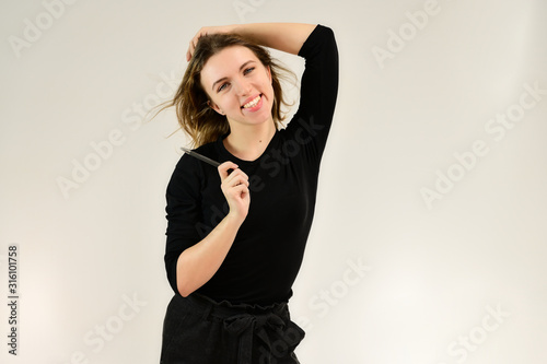 A universal concept, the picture is suitable for any topic. Studio portrait of a pretty blonde girl in a black T-shirt on a white background with bright emotions.