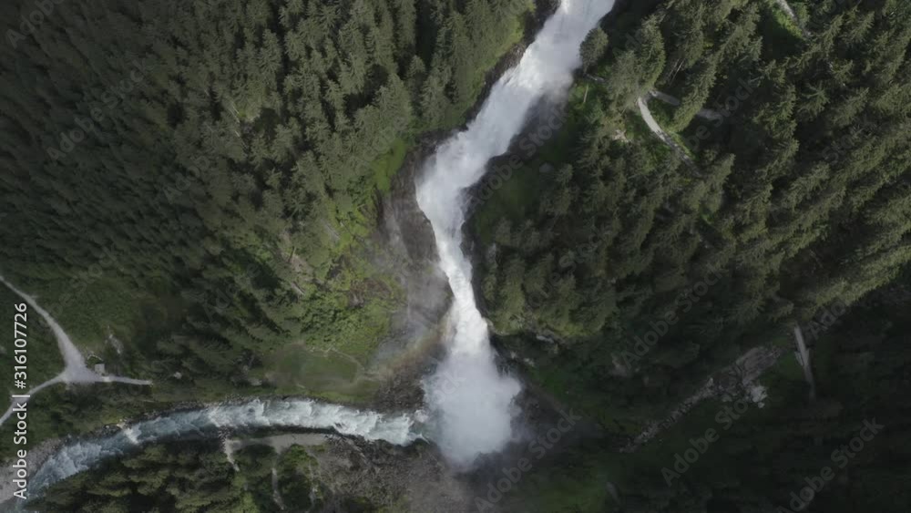 Aerial top down view of Krimml waterfall Cascades, Austria. Drone flight above strong water flow on rocks between spruce forest. Rainbow. Aerial top down view of Krimml waterfall Cascades, Austria. Drone flight above strong water flow on rocks between spruce forest. Rainbow.