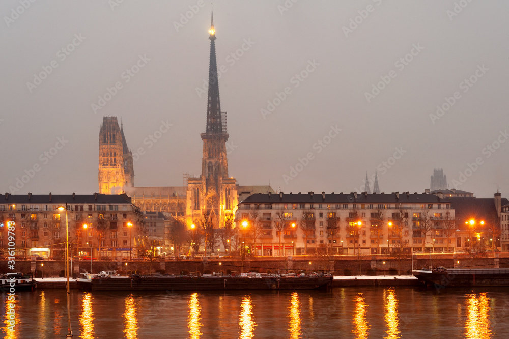 Rouen cathedral and historic city center along Seine river at night, Normandy, France