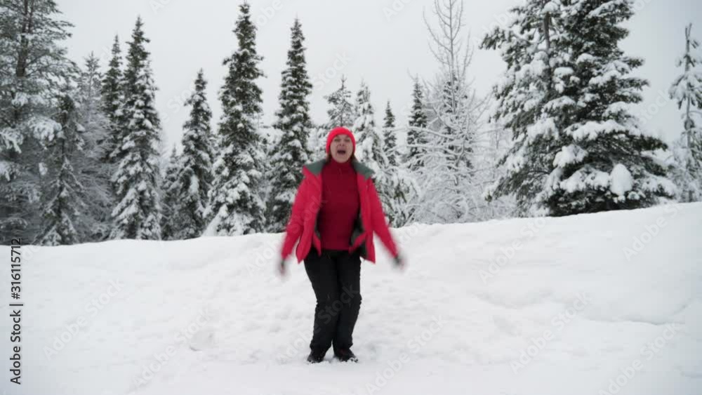 Happy woman jumping like a star in a wild forest in Finland in winter in slo-mo Happy woman jumping like a star in a wild forest in Finland in winter in slo-mo